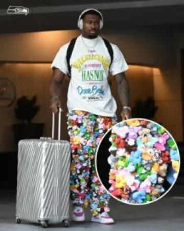 Maleta de viaje extendida de aluminio plateado Tumi usada por DK Metcalf en la cuenta de Instagram @houstontexans