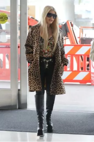 Botas de plataforma hasta la rodilla de Versace en cuero negro usadas por Jessica Simpson en el aeropuerto de Los Ángeles el 7 de octubre de 2024