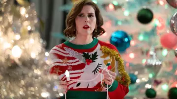 Atuendos de Elsbeth Temporada 2: DeeDee Dashers (Vanessa Bayer) usa un suéter navideño adornado con unicornio en el episodio 6