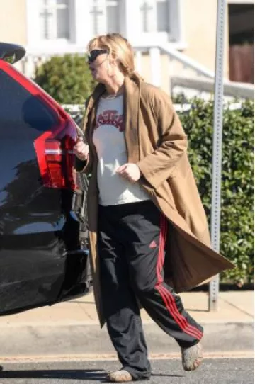 Pantalones de running Adidas Athletic Black Red Stripes usados por Jennifer Lawrence en Los Ángeles el 20 de noviembre de 2024
