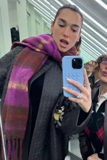 Abrigo de cuero Bottega Veneta Intrecciato usado por Dua Lipa en su publicación de Instagram el 5 de diciembre de 2024
