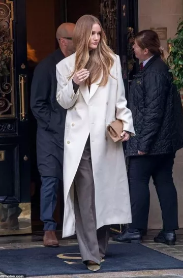 La pochette en cuir brillant beige amazonien Row portée par Rosie Huntington-Whiteley à Londres le 7 décembre 2024