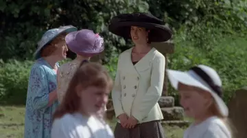 Tenues de quatre mariages et d’un enterrement : Carrie (Andie MacDowell) porte une veste à double boutonnage crème avec une jupe assortie jusqu’à la cheville pour le premier mariage