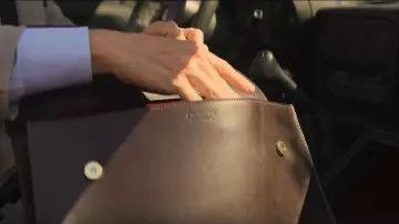 Brown folio bag of The Jackal (Eddie Redmayne) in The Day of the Jackal (S01E01)