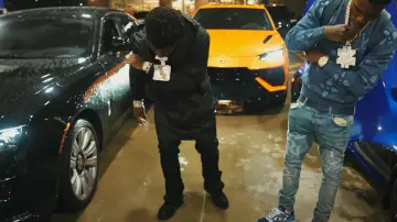 Amiri Black Waxed Staggered Logo Jeans worn by BossMan Dlow in Zillionaire Doe - Pull Up (Official Music Video) ft. BossMan Dlow