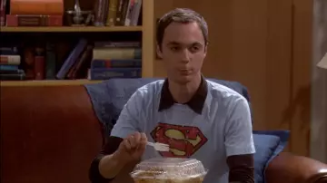 Camiseta azul claro con el logotipo del escudo de Superman de Sheldon Cooper (Jim Parsons) en The Big Bang Theory (S01E02)
