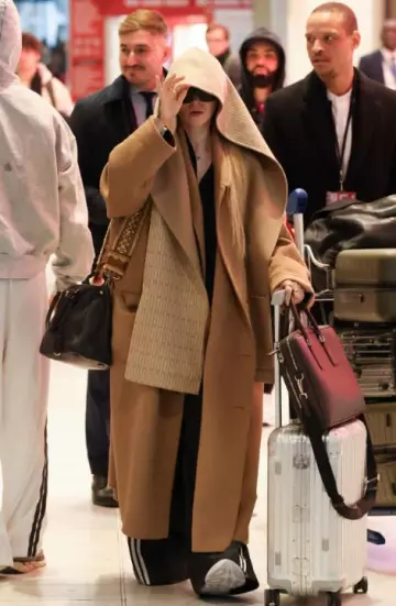 Prada Double Wool Hooded Scarf worn by Dove Cameron at Airport in Paris on March 4, 2025