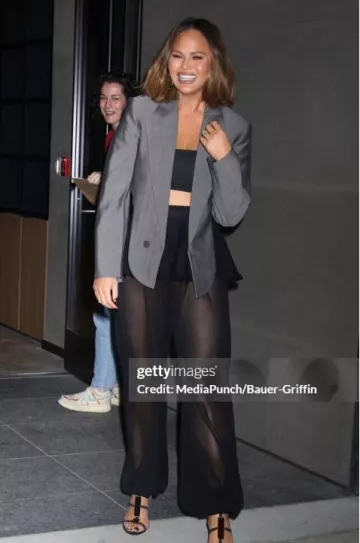 Pantalon péplum en tricot Alaia porté par Chrissy Teigen à Watch What Happens Live le 12 mars 2025