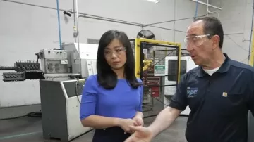 Haut à col enveloppe extensible raffiné Ann Taylor en bleu éblouissant porté par Weijia Jiang comme on le voit dans CBS Mornings le 29 avril 2025