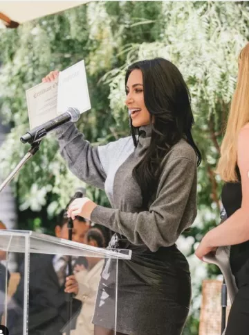 Gianni Versace 1980’s Embossed Black Leather Tie Front Grey Wool Mini Skirt worn by Kim Kardashian West at Graduation Party on May 21, 2025