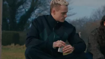 Cardigan zippé foncé à motif argyle vert et col haut porté par Eddie Harrigan (Anson Boon) dans MobLand (S01E07)