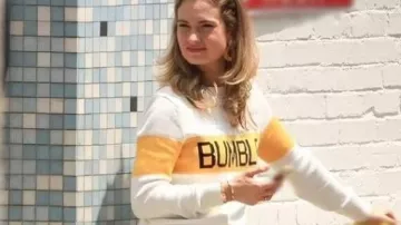 Sudadera blanca y amarilla con Swiped usada por Whitney (Lily James) como se ve en Swiped