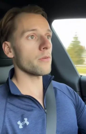 Neal Huybens (Judge Neal) driving a Tesla Model 3 wearing a Under Armour UA Fleece