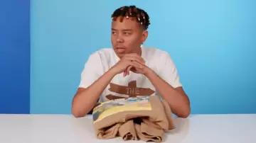 Merch Cordae Beige The Lost Boy Album Merch Hoodie worn by YBN Cordae in 10 Things YBN Cordae Can't Live Without | GQ