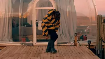 Chaqueta acolchada de chevron amarillo y negro Rhude usada por DDG en DDG - Vegano (Video musical oficial)