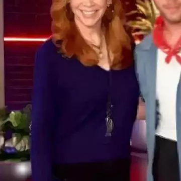 Suéter con cuello en V con puño de plumas azul usado por Reba McEntire en The Voice S28