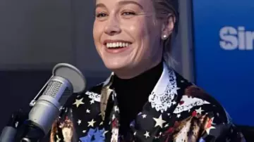 Abrigo largo estampado SiriusXM Studios 2025 usado por Brie Larson en Brie Larson y Jessie Ennis toman una prueba de amistad | Glamur