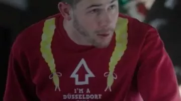 Un Noël très Jonas Nick Jonas « I’M A Düsseldorf GIRL » Sweat-shirt de Nick Jonas (Nick Jonas) dans un film de Noël très Jonas