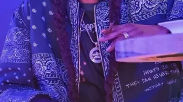 Chaqueta de proyección del álbum que lleva Snoop Dogg en Snoop Dogg - Drop It Like It's Hot (Vídeo musical oficial) ft. Pharrell Williams