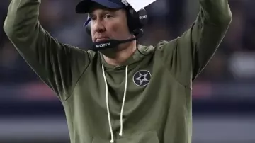 Brian Schottenheimer Dallas Cowboys saluda a la sudadera de servicio en Cómo elegir la camiseta NFL de la talla adecuada (Edición Nike)