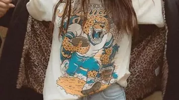 Camiseta de gráficos de Jacksonville Jaguars Run que lleva Travis Hunter en HIGHLIGHTS | Las mejores carreras de carrera de Travis Etienne Jr. (hasta ahora) | Jacksonville Jaguars