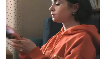 Emily In Paris S05 Emily Cooper Orange Slogan Hoodie worn by Emily Cooper (Lily Collins) in Emily in Paris (S05)