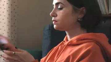 Emily In Paris S05 Lily Collins Orange Slogan Hoodie worn by Emily Cooper (Lily Collins) as seen in Emily in Paris (S05)