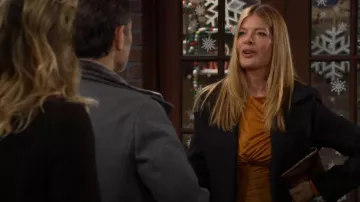 Bolso de mano metálico True Decadence en bronce usado por Phyllis Summers (Michelle Stafford) visto en The Young and the Restless el 12 de diciembre de 2025