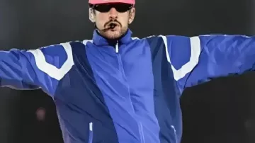Bad Bunny porte une veste de survêtement bleue lors de sa tournée 2026 et du spectacle de la mi-temps du Super Bowl sur Apple Music.