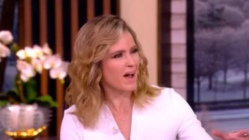 Blusa asimétrica de manga larga con botones de Veronica Beard Brenner, usada por Sara Haines, en The View el 23 de febrero de 2026.