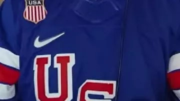 Maillot bleu porté par Travis Kelce dans la réaction choquée de Travis Kelce lorsque Taylor Swift interprète Opalite dans le podcast New Heights