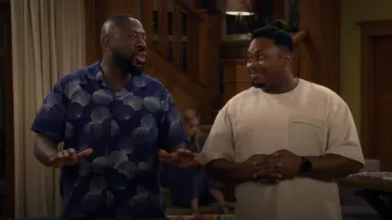 Modo de una camiseta francesa mixta relajada de bolsillo de franja que lleva Marty Butler (Marcel Spears) tal como se ve en The Neighborhood (S08E15)
