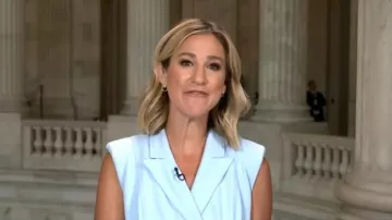 Calvin Klein Belted Peak Lapel Wrap Midi Dress worn by Caitlin Huey-Burns as seen in CBS Mornings on July 16, 2026