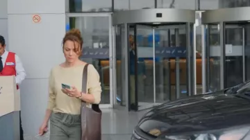 Sac à bandoulière réglable Mango Buckle Detail de couleur marron foncé porté par Maca (Silvia Navarro) dans l'épisode « Le père de ma fille » (S01E02).