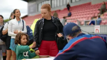 Veste bomber boutonnée bleue à manches longues Adesa pour femme de la marque Hugo, portée par Niamh (Aisling Sharkey) dans l'épisode Ted Lasso (S04E03).