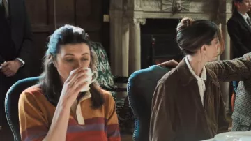 Camiseta de rugby de rayas naranja, marrón y morada que lleva Charly Horniman (Jasmine Blackborow) como se ve en The Gentlemen (S02E01)