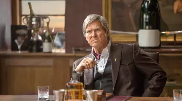 Gold Pla­ted Dol­lar Sign worn by Champagne Agent (Jeff Bridges) in Kingsman: The Golden Circle