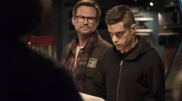La insignia de Mr. Robot en la chaqueta de Christian Slater en Mr. Robot