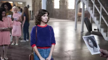 Le pull bleu et rouge en velours de Ruth (Alison Brie) dans Glow