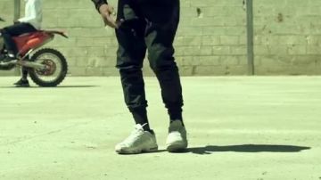 El par de Nike TN blancas de Oboy en su clip Cobra