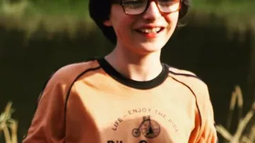 "Enjoy the Ride - Bike & Cycle Shoppe" Orange tee shirt worn by Richie Tozier (Finn Wolfhard) as seen in It