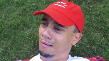 La gorra roja de WLKN "Woman Worldwide" de Mister V en el video The Service