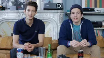The navy blue Lacoste polo shirt worn by Samuel (Pierre Niney) in the movie Five