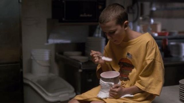 Benny's Burger yellow tee shirt worn by Eleven (Millie Bobby Brown) as seen in Stranger Things S01E01