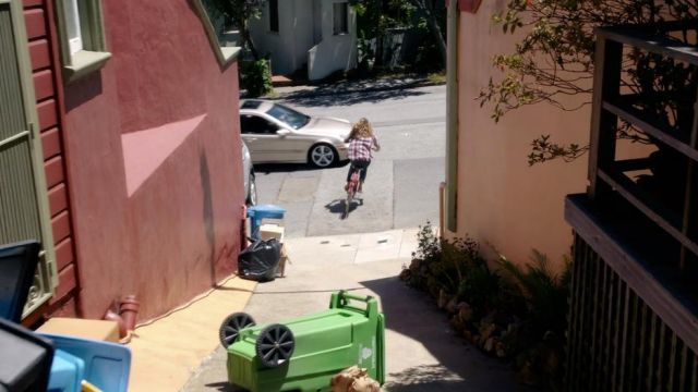 Une allée de San Francisco traversée à vélo par Nomi Marks (Jamie Clayton) dans Sense8 S01E08