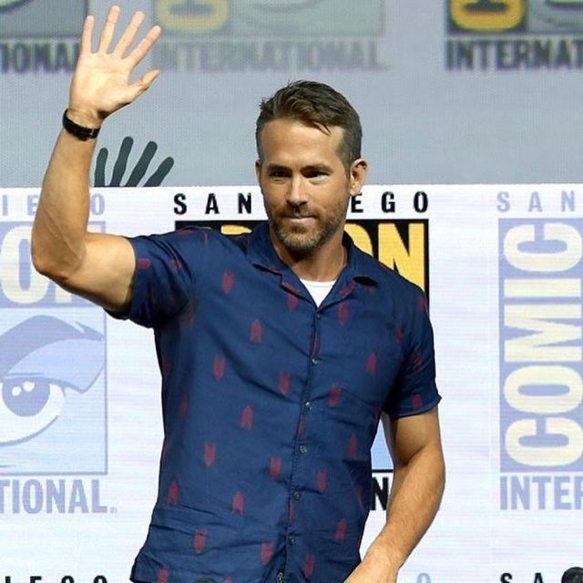 The shirt is navy with pattern of Ryan Reynolds on his account Instagram