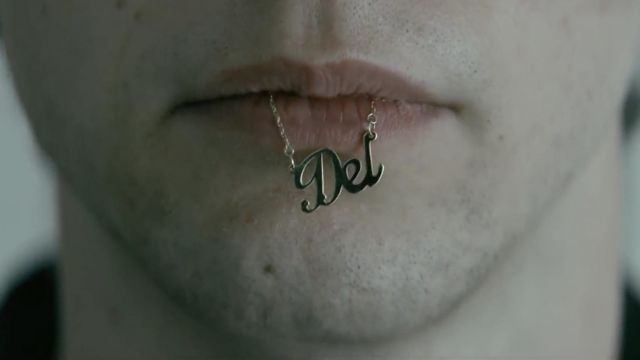'Del' Necklace in the mouth of Wayne McCullough (Mark McKen­na) as seen in Wayne TV series outfits (Season 1 Episode 10)