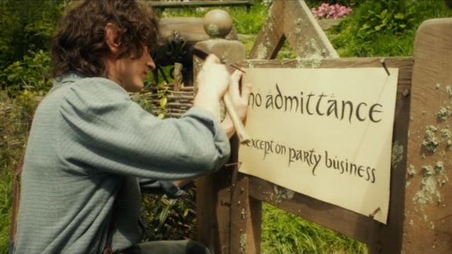 La pancarte No admittance Except on party business chez Bilbon Sacquet (Ian Holm) dans Le seigneur des anneaux : La communauté de l'anneau