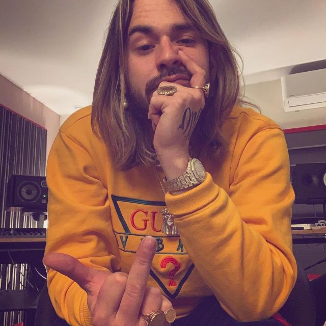 The sweatshirt yellow Guess x J. Balvin worn by SCH on his account Instagram