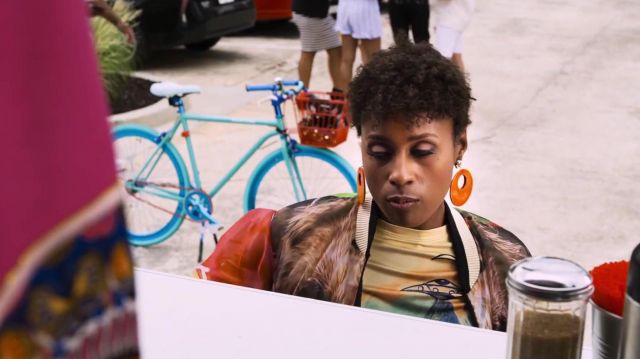 Les boucles d'oreilles oranges portées par April Williams (Issa Rae) dans Little